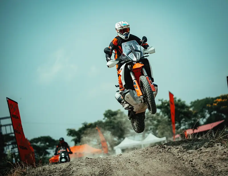 Adventure motorcycle launching off a dirt jump