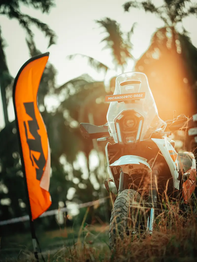 Adventure motorcycle parked in long grass at golden hour