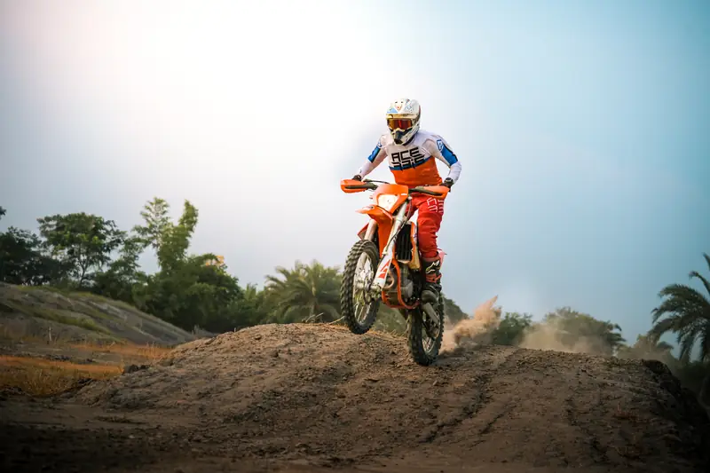 Dirt bike cresting a mound of earth