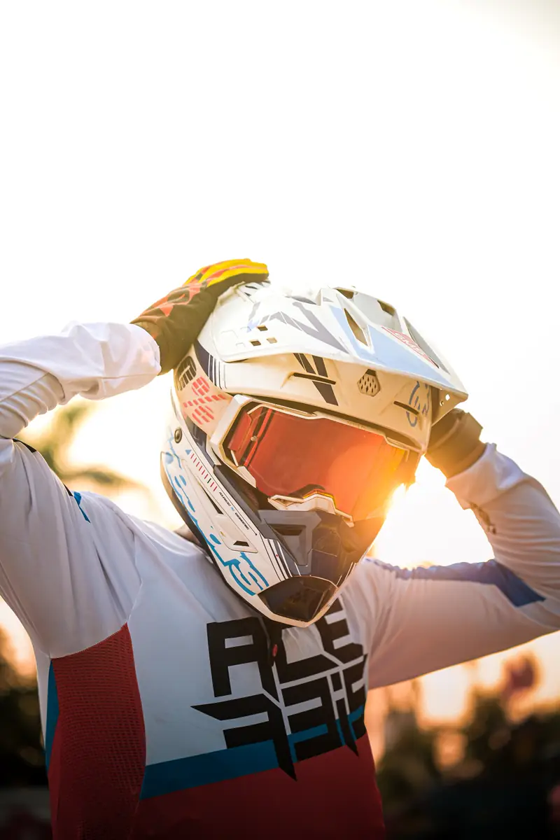 Rider pulling on a helmet in warm backlight