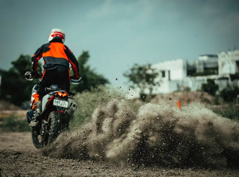 Rear wheel throwing a wall of dirt out of a turn