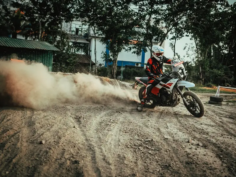 Rider sliding an adventure bike through a cloud of dust