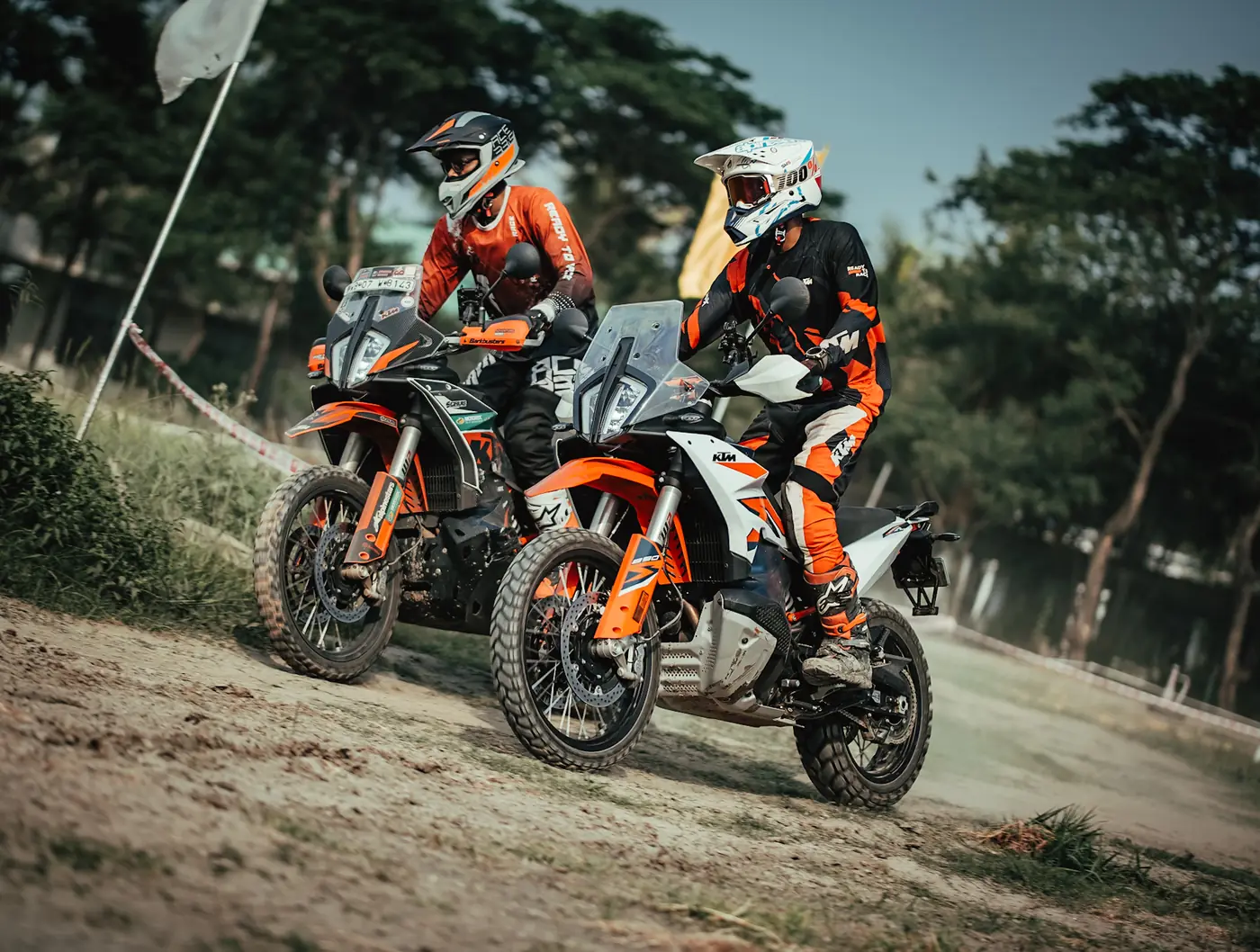 Two riders on adventure motorcycles on a dirt track